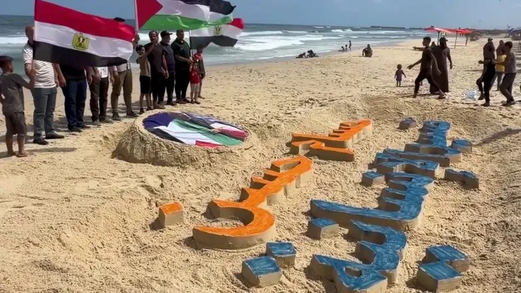 شاب فلسطيني يكرّم حسام حسن بلوحة رملية على شاطئ غزة