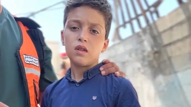 الطفل محمد غبون ينتظر وداع أهله تحت أنقاض غزة